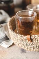 Glass of hot tea in jute basket in home interior. Breakfast food concept photo