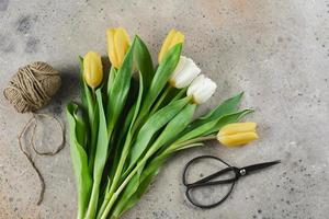 Spring tulips, jute rope, scissors on background. Spring holidays concept. 8 march and mother's day holiday. photo