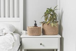 Scandinavian interior in white colors. Home plant in jute basket. Lifestyle authentic concept. photo