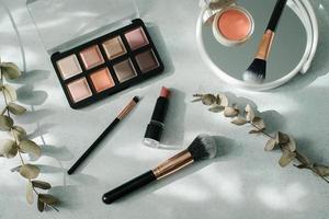 Makeup brushes and cosmetics on light background. Beauty, fashion concept.