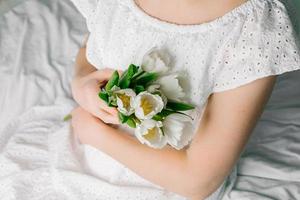 Bouquet of white tulips in woman's hands. Concept of International Women's day or Mother's day. photo