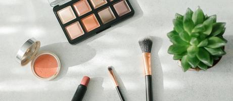 Makeup brushes and cosmetics on light background. Beauty, fashion concept. Banner for design, web format photo