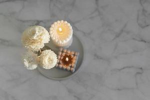 Home aroma fragrance diffuser and burning candles on marble background. Top view photo