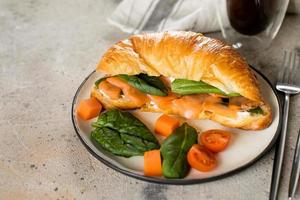 Croissant sandwich with cottage cheese, salmon, spinach. Healthy breakfast. photo