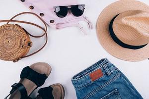 Bodegón de verano por encima de la cabeza. ropa casual de mujer, accesorios. vacaciones, concepto de viaje. endecha plana foto