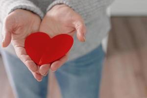 Female hands holding red heart. Concept of health care, donate, wellness photo