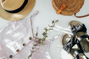 concepto de blog de belleza. ropa femenina de verano, accesorios. sandalias negras, top, sombrero de paja, bolso de mimbre foto