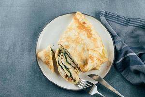 Crepes with stuffed cream cheese, spinach, turkey. Cuisine meal food concept. photo