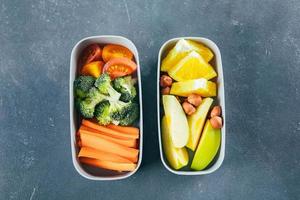 Two snack boxes with vegetables and fruits. Delicious balanced food concept. Top view photo