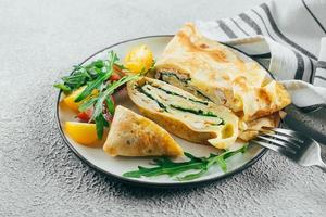 Crepes with stuffed cream cheese, spinach, turkey. Cuisine meal food concept. Closeup photo