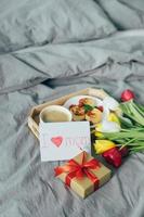 Healthy branch, gift box and fresh tulips for Morher's day. Romantic surprise with tasty breakfast photo