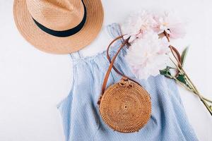 Women's fashion summer clothes, accessories. Stylish female straw hat, blue dress, rattan bag, peony photo