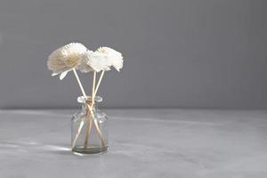 Aromatic reed air freshener on marble table background. Hygge, cozy concept. Copy space photo