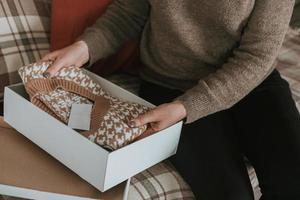 Female hands holding knitted vest or sweater. Concept of online shopping, unpacking gift photo