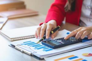 Marketing, Financial, Accounting, Planning, business women analyze company results and profits with graph statistics. Use a laptop computer and a calculator to calculate the company is balance.