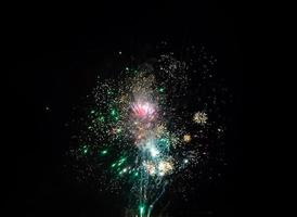 Beautiful colorful firework explosions and sparkles on a night black sky photo