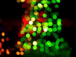 defocused abstract background with red and green bokeh light dots on a dark background photo
