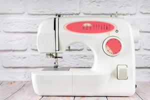 Modern sewing machine on table in tailor's workshop photo