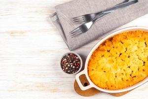 Shepherd's Pie or Cottage Pie, traditional British dish on white wooden background photo