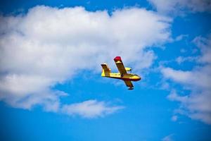 Bright Yellow Firefighter Plane in a Blue Sky photo