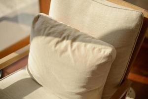 Cozy style. Beige cushions decorate the house on the sofa at afternoon. photo