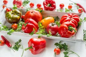 Fresh tomatoes and peppers on the wooden tray photo