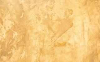 Abstract grunge decorative golden stucco wall with scratches, scuffs background. Art-stylized texture banner with copy space. photo