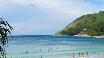 Vacationers people, tourists in the waves on the Nai Harn beach, pan view video