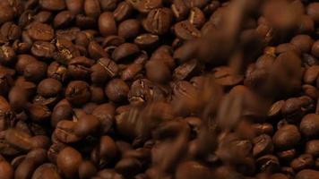 Zeitlupe von fallenden gerösteten Kaffeebohnen. Bio-Kaffeesamen.