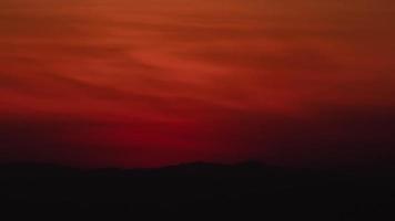 Sunrise over a mountain in the orange sky 4k time lapse video.