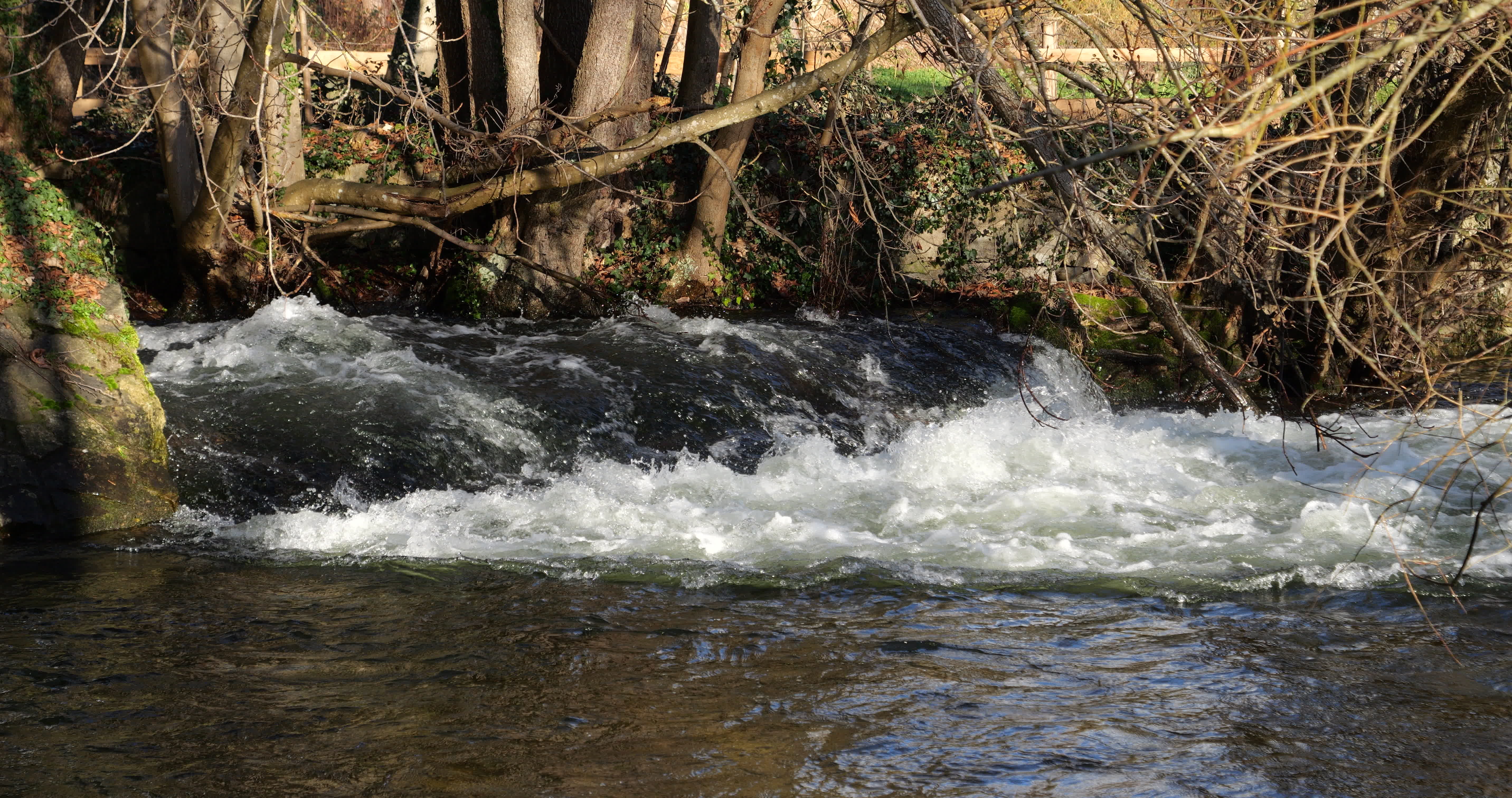 Small waterfall with water splashing and tumbling over the rocks