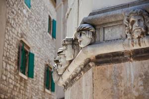 Stone heads at Cathedral of St. James in Sibenik, Croatia photo