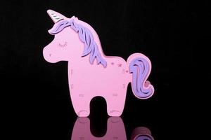 unicornio de juguete rosa de un niño sobre un fondo oscuro foto