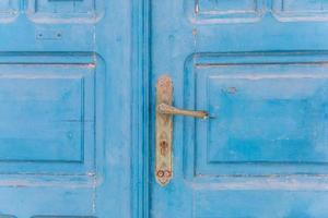 Faded old rustic blue door on the island of Santorini Greece, traditional colors sunlight fade tourism greek islands photo