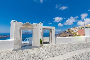 arquitectura blanca tradicional y puerta con vistas al mar mediterráneo en el pueblo de fira en la isla de santorini, grecia. fondo de viaje escénico. hermoso concepto de vacaciones de verano, increíble cielo azul foto