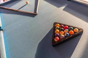 mesa de billar y bolas. taco de billar y bolas en una mesa de paño azul suave. bolas de billar en una mesa de billar. concepto de deporte y recreación de vacaciones, imagen deportiva abstracta foto