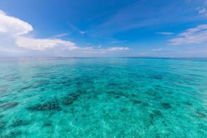 Summer sea beautiful of exotic tropical beach. Emerald green of the sea and bright blue sky with clouds with sunlight. Summer seascape, turquoise ocean water, idyll island or beach banner photo