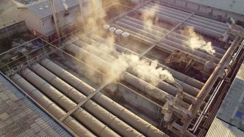 centrarse en los humos tóxicos esparcidos desde el techo de una planta industrial. Las plantas industriales emiten grandes cantidades de humo blanco de las fábricas durante la producción. que crea la contaminación del aire para el mundo.