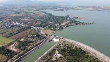 uma vista aérea sobre a barragem de pasak jolasid, província de lopburi, tailândia. acompanhando o movimento das comportas que estão liberando água em canais rurais em enormes quantidades de água. video