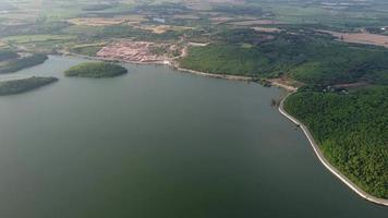 réservoir de muak lek à saraburi depuis une vue aérienne à vol d'oiseau. belle nature invisible au barrage de muak lek avec une chaussée à côté avec de l'eau et une colline d'arbres. video