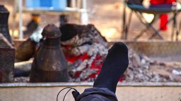 Human Feet Resting in Front of Campfire