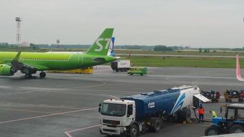 novosibirsk, federación rusa 24 de julio de 2021 - avión de pasajeros s7 airlines rodando en la pista del aeropuerto de tolmachevo. vista desde la ventana de la terminal en el aeródromo del aeropuerto. video