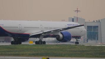 MOSCOW, RUSSIAN FEDERATION JULY 28, 2021 - Commercial plane boeing 777 of Aeroflot taxiing on the runway at Sheremetyevo Airport. Airplane turns airport background. Tourism and travel concept video