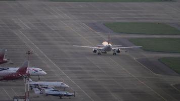 SOCHI, RUSSIA JULY 27, 2022 - Airplane towing on the airfield at sunset or dawn. Tourism and travel concept video