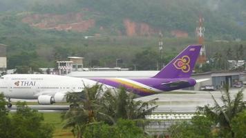 phuket, thailand december 02, 2016 - boeing 747 av thai luftvägarna tar av på phuket flygplats, sida se. jumbo jet avresa. flygfält, handflatan träd video