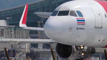 PHUKET, THAILAND NOVEMBER 14, 2019 - Low cost of AirAsia taxiing to the runway, departure at Phuket airport HKT. Medium shot, passenger plane at taxiway. Tourism and travel concept video