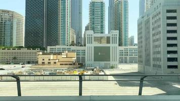 Dubai, UAE, 2022 - metro passengers point of view to cityscape glass commercial buildings in sunny daylight.Commute to work and explore travel in United Arab Emirates video