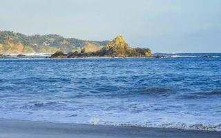 mazunte mexico hermosa playa paradisíaca con montañas acantilados rocas olas. foto