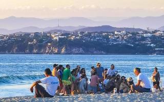 Puerto Escondido Oaxaca Mexico 2022 Colorful golden sunset people wave and beach Puerto Escondido Mexico. photo