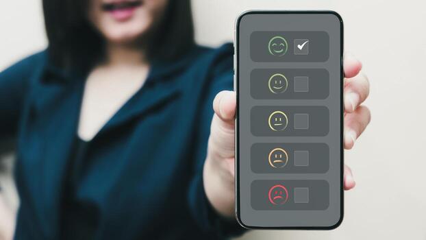 la mano de la persona que usa el teléfono inteligente le da un icono de cara sonriente feliz y un símbolo de cinco estrellas para aumentar la calificación del concepto de producto y servicio, la experiencia de servicio al cliente y la encuesta de satisfacción comercial. foto